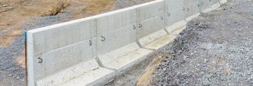rząd ścianek oporowych prefabrykowanych ułożonych na podłożu żwirowym, ścianki oporowe prefabrykowane z betonu