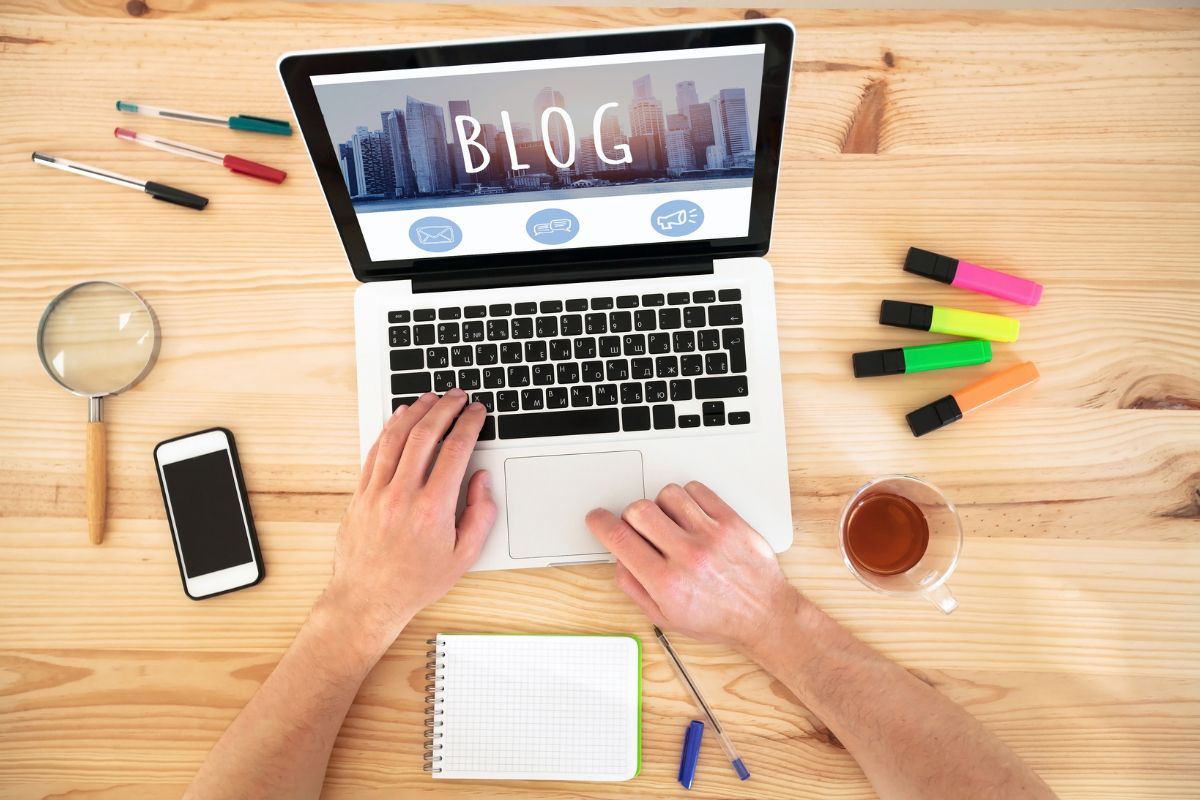 jak skutecznie wypozycjonować swój blog? Drewniane biurko a na nim laptop z napisem blog