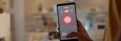 mezczyzna za pomoca aplikacji inteligentnego domu dotyka ekranu aby wlaczyc swiatlo przez telefon komorkowy