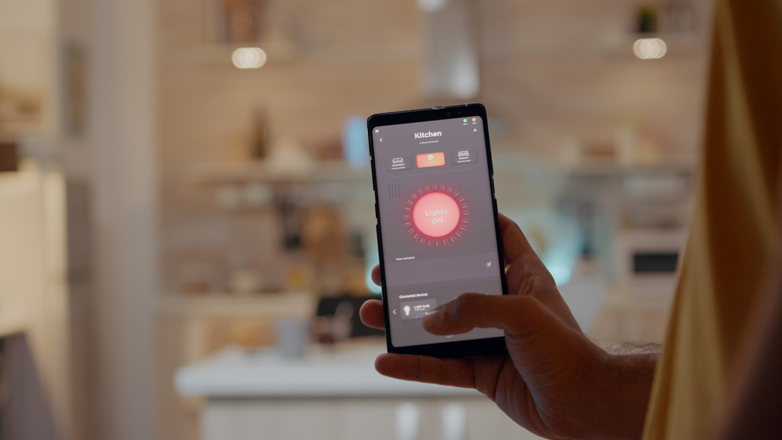 mezczyzna za pomoca aplikacji inteligentnego domu dotyka ekranu aby wlaczyc swiatlo przez telefon komorkowy