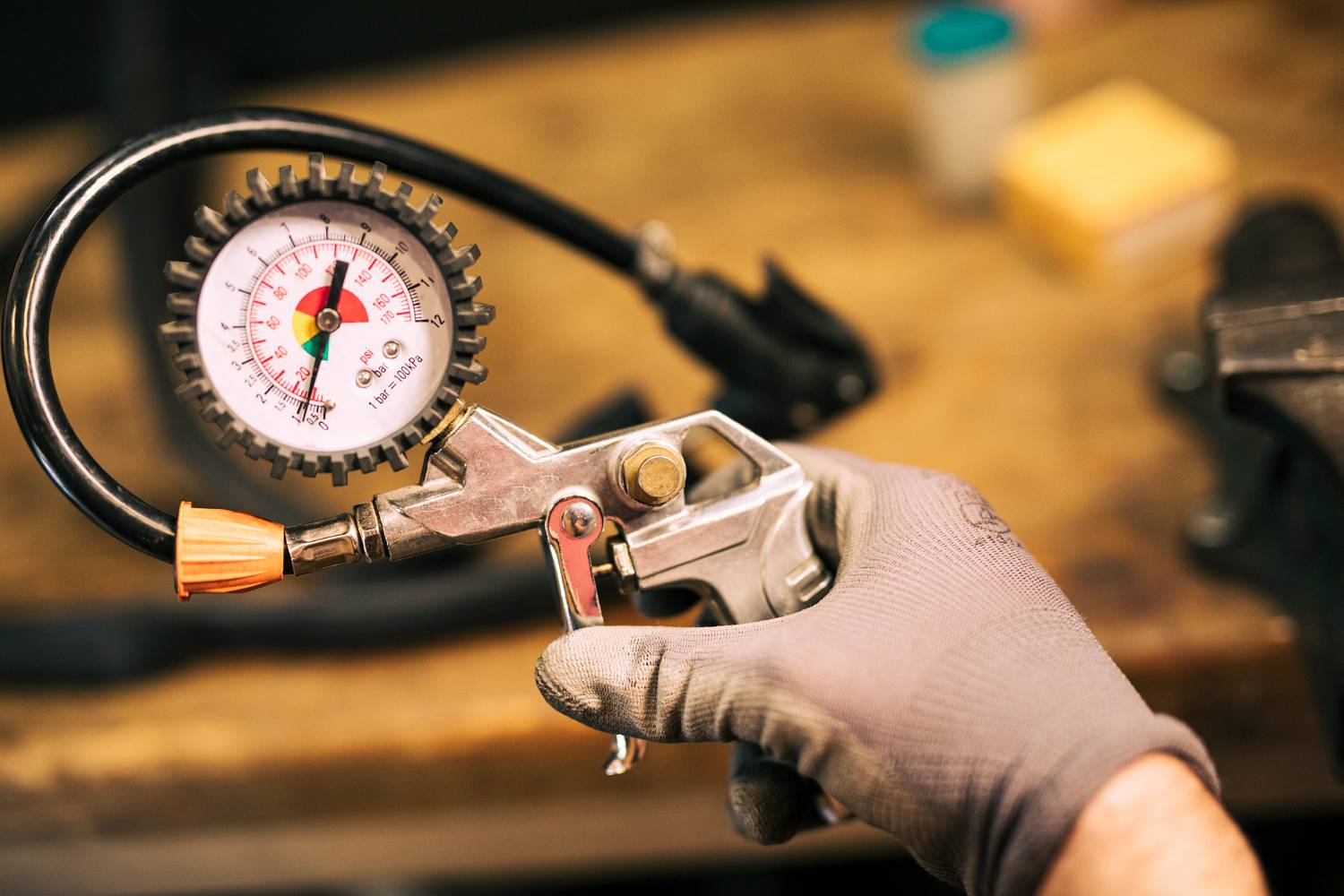 mechanik naprawiajacy rower, miernik ciśnienia w oponach, reduktor do gazu
